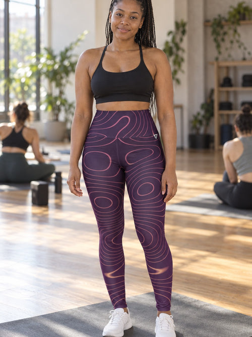 Woman wearing the Coral Topo high-waisted yoga leggings with the Vantacore V emblem on the hip – front view