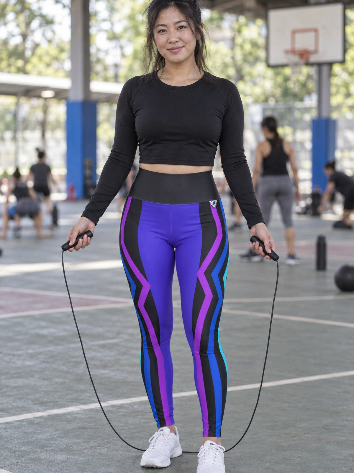 Woman wearing the Electric Vortex High-Waisted Yoga Leggings with the Vantacore V emblem on the hip – front view