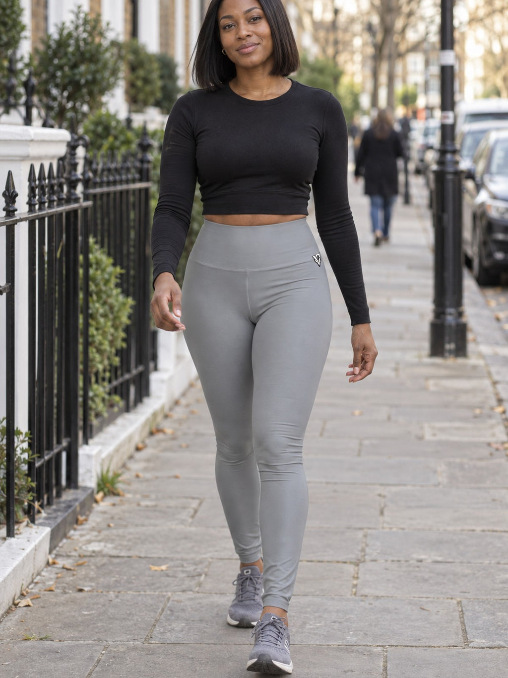 Woman wearing the Stone Grey Essential High-Waisted Yoga Leggings with the Vantacore V emblem on the hip – front view
