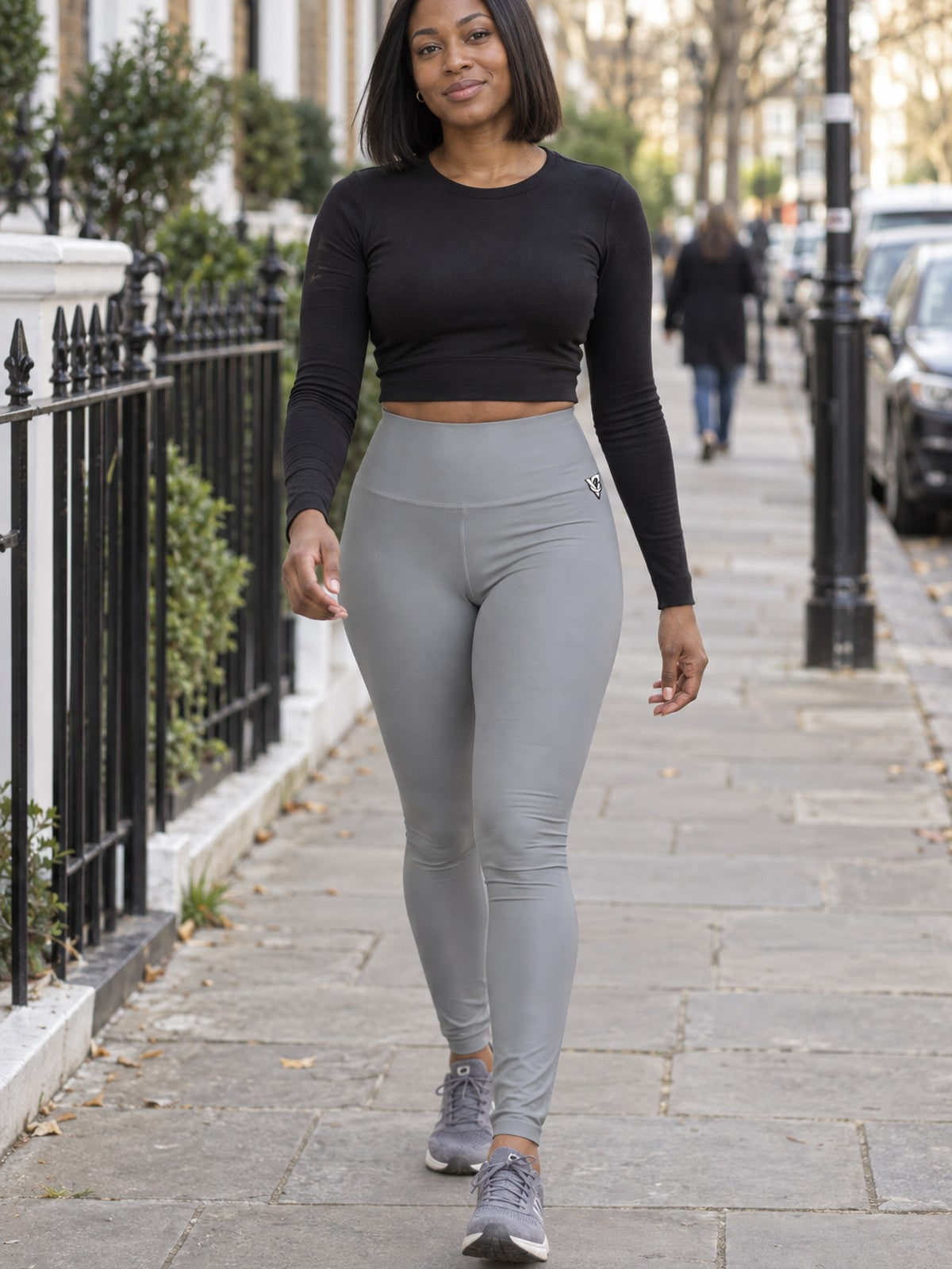 Woman wearing the Stone Grey Essential High-Waisted Yoga Leggings with the Vantacore V emblem on the hip – front view