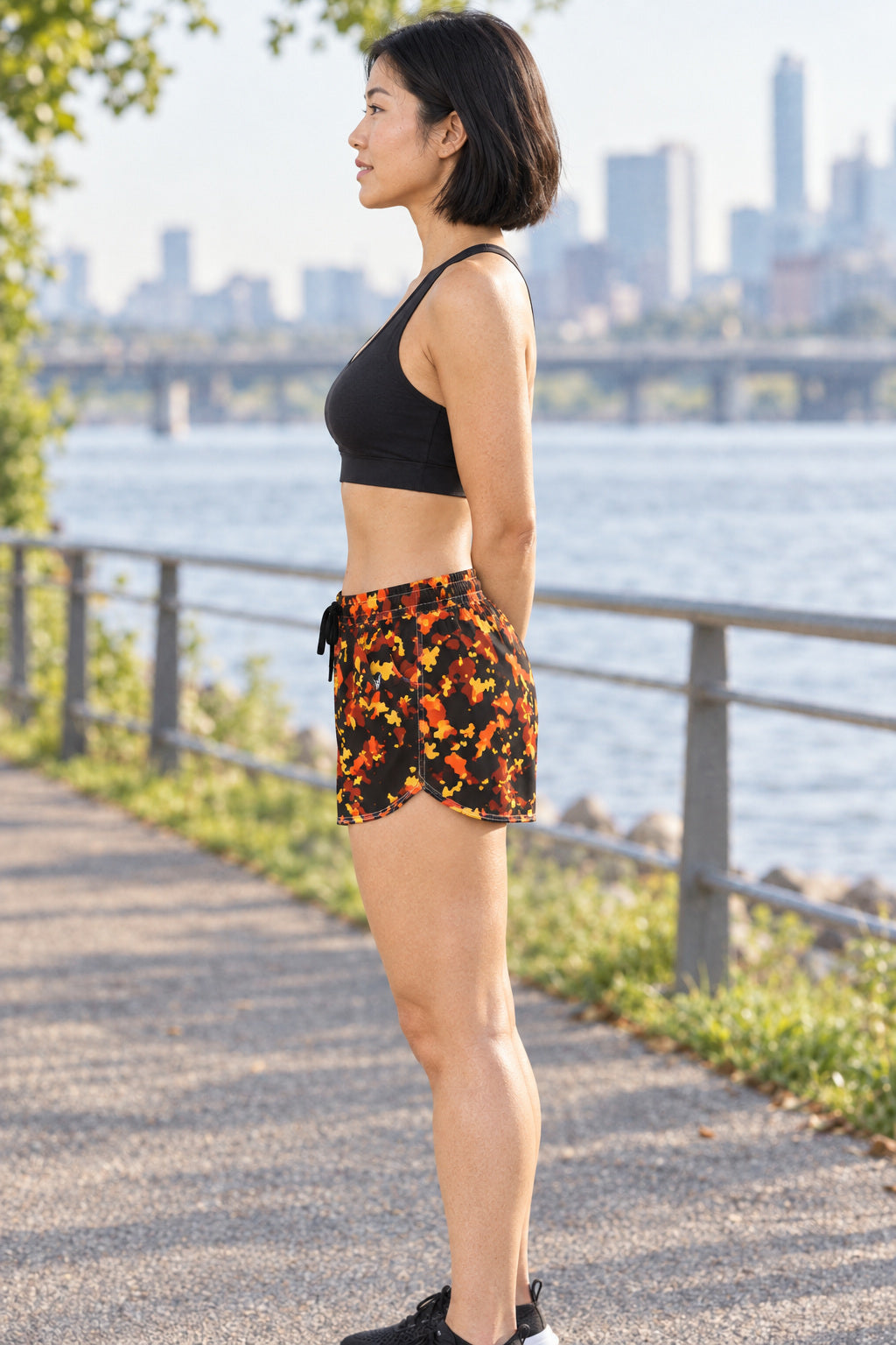 Women's Multipurpose Athletic Shorts with Pockets | Ember Splatter, AI-generated side-profile product mockup on a fictional adult model