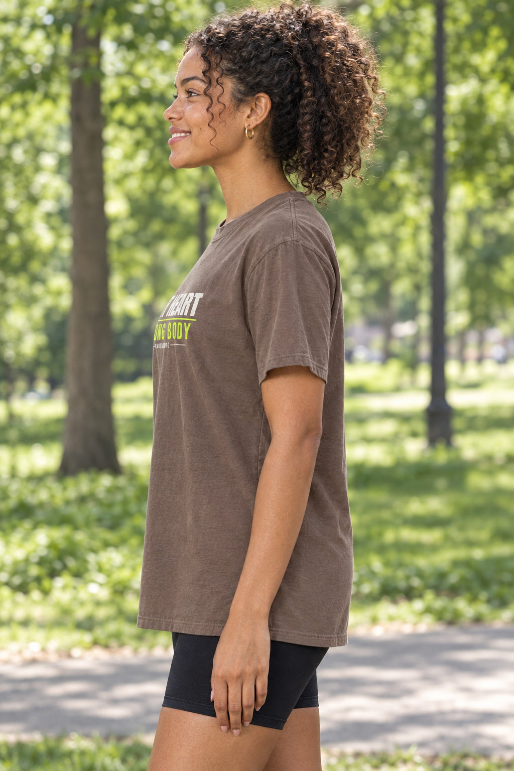 Soft Heart Strong Body | Women's Garment-Dyed Graphic Tee, AI-generated side-profile product mockup on a fictional adult model