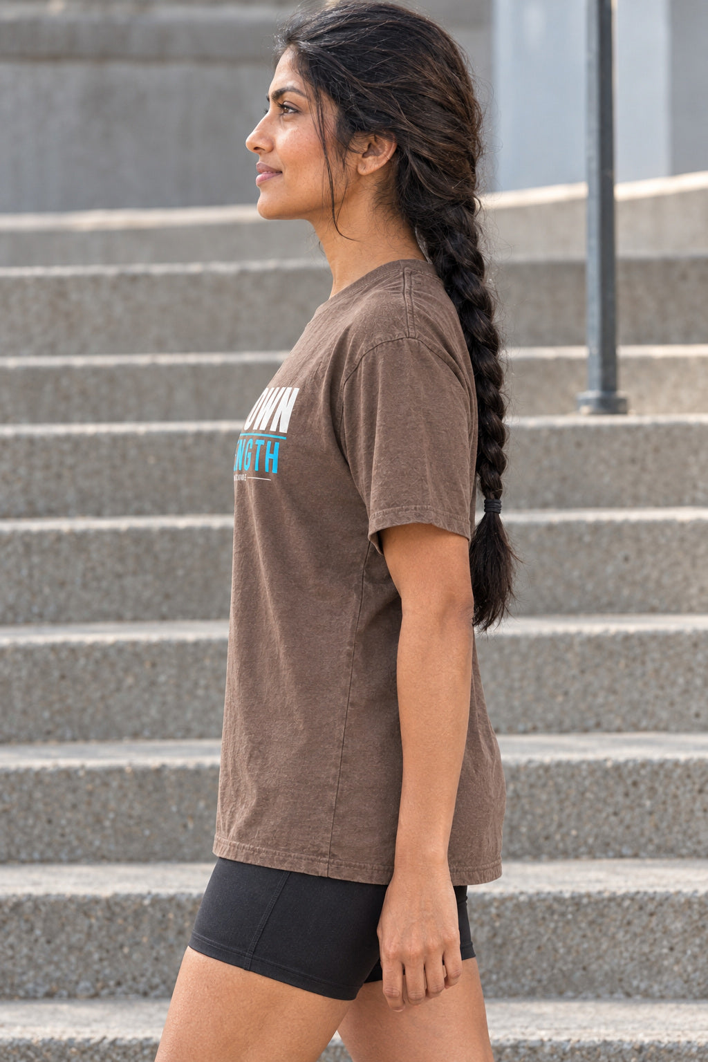 Her Own Strength | Women's Garment-Dyed Graphic Tee, AI-generated side-profile product mockup on a fictional adult model