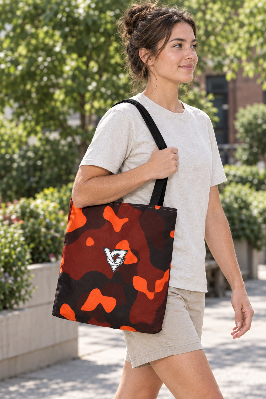 Ember Camo Tote Bag — All-Over Print Gym & Everyday Tote, AI-generated realistic three-quarter mockup on a fictional adult model