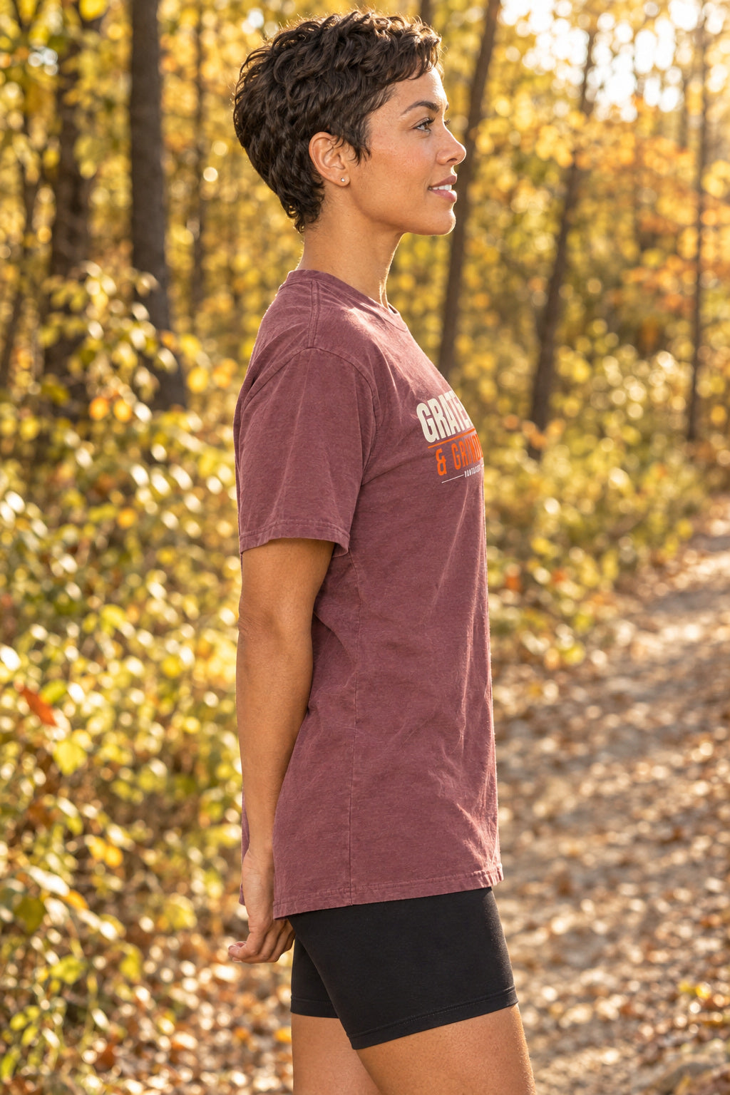 Grateful & Grinding | Women's Garment-Dyed Graphic Tee, AI-generated side-profile product mockup on a fictional adult model