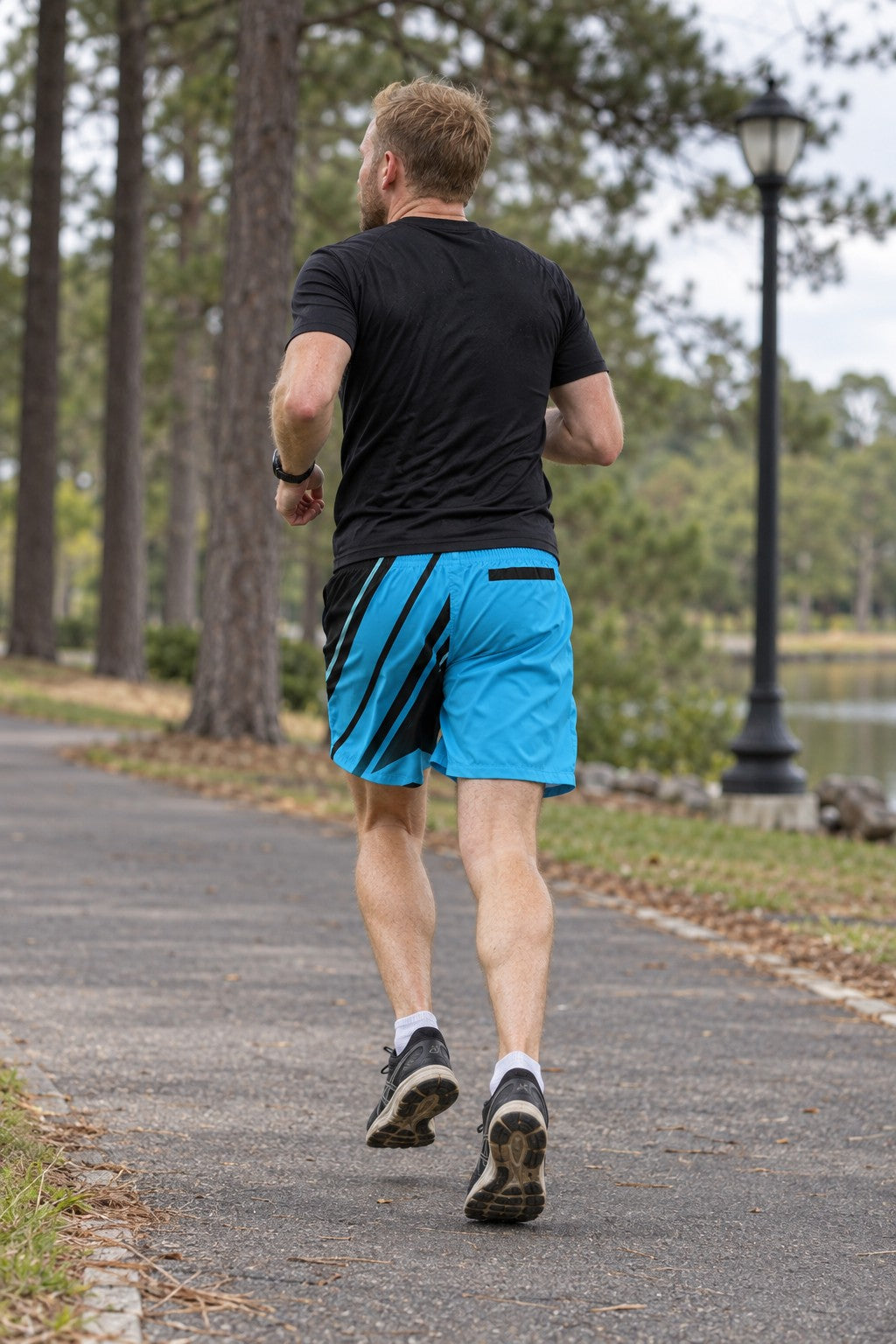 Runner wearing Men's Electric Cyan & Black Running Jogger Shorts with Pockets — Athletic Performance AOP — rear view