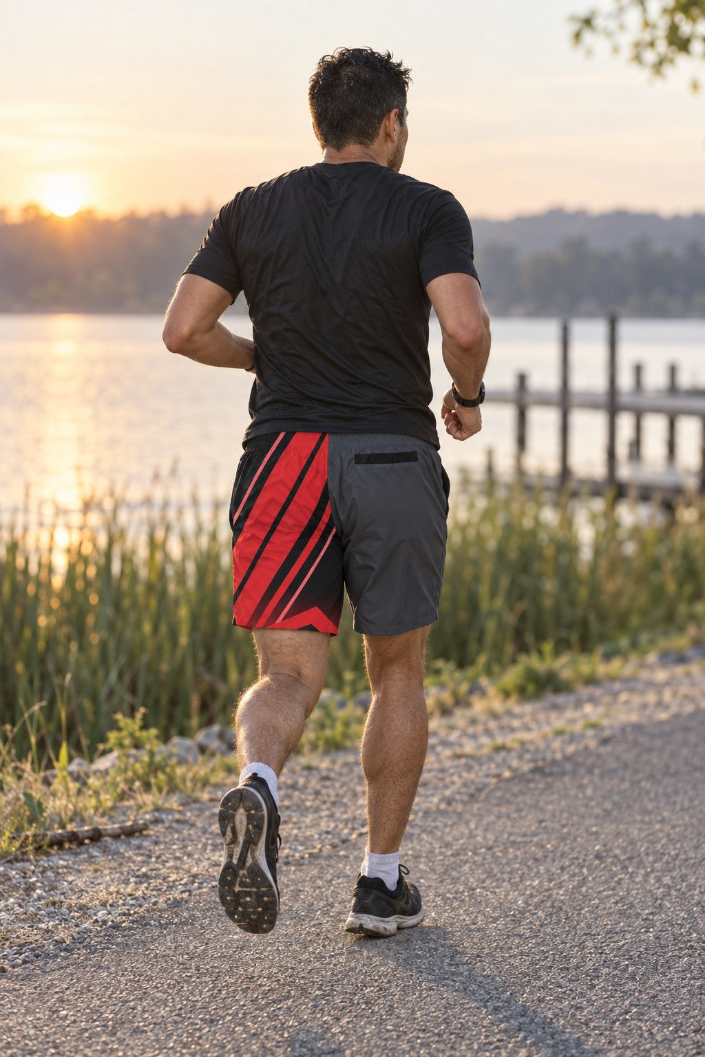 Runner wearing Men's Gunmetal & Red Running Jogger Shorts with Pockets — Athletic Performance AOP — rear view