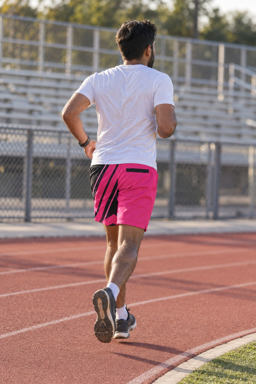 Runner wearing Men's Neon Pink & Black Running Jogger Shorts with Pockets — Athletic Performance AOP — rear view