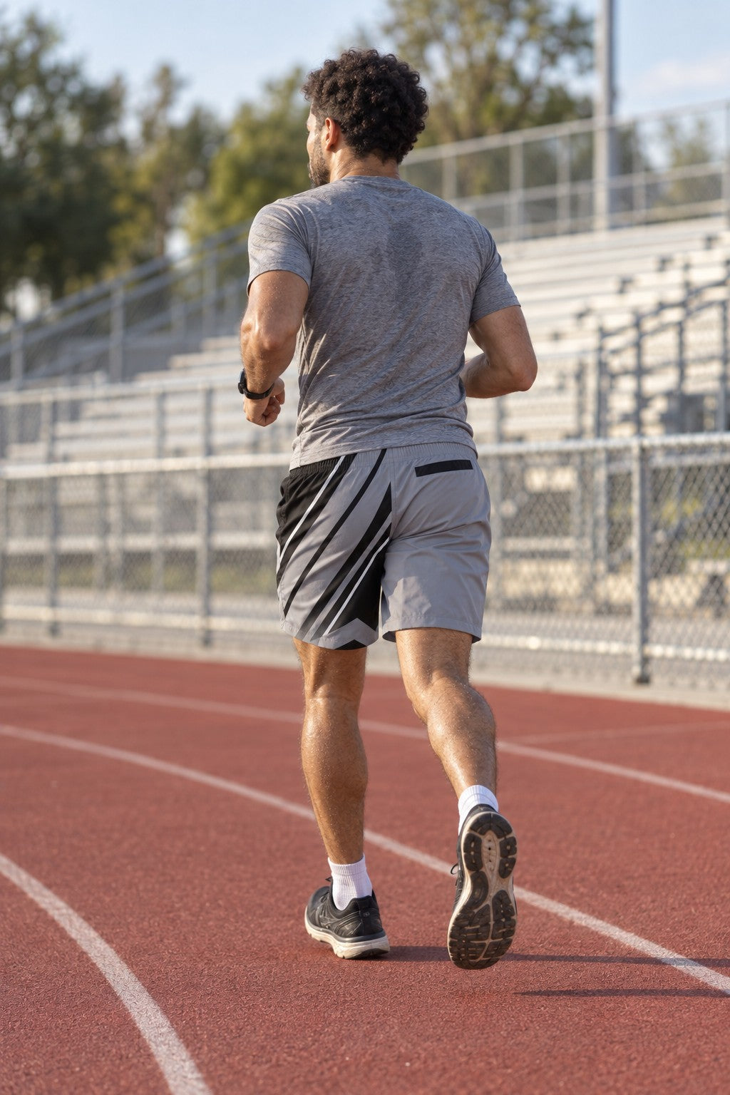 Runner wearing Men's Steel Gray & Black Running Jogger Shorts with Pockets — Athletic Performance AOP — rear view