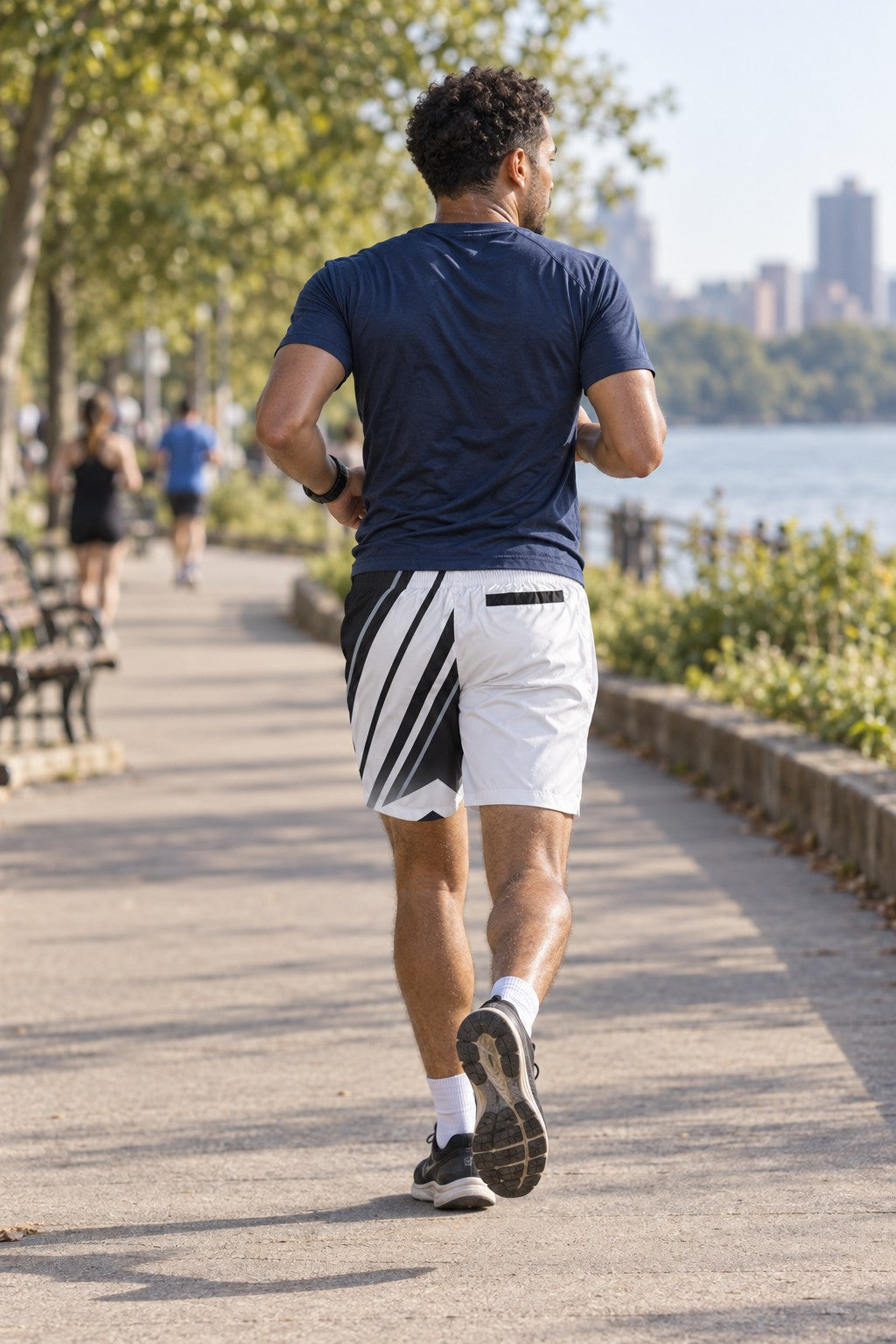 Runner wearing Men's Arctic White & Black Running Jogger Shorts with Pockets — Athletic Performance AOP — rear view
