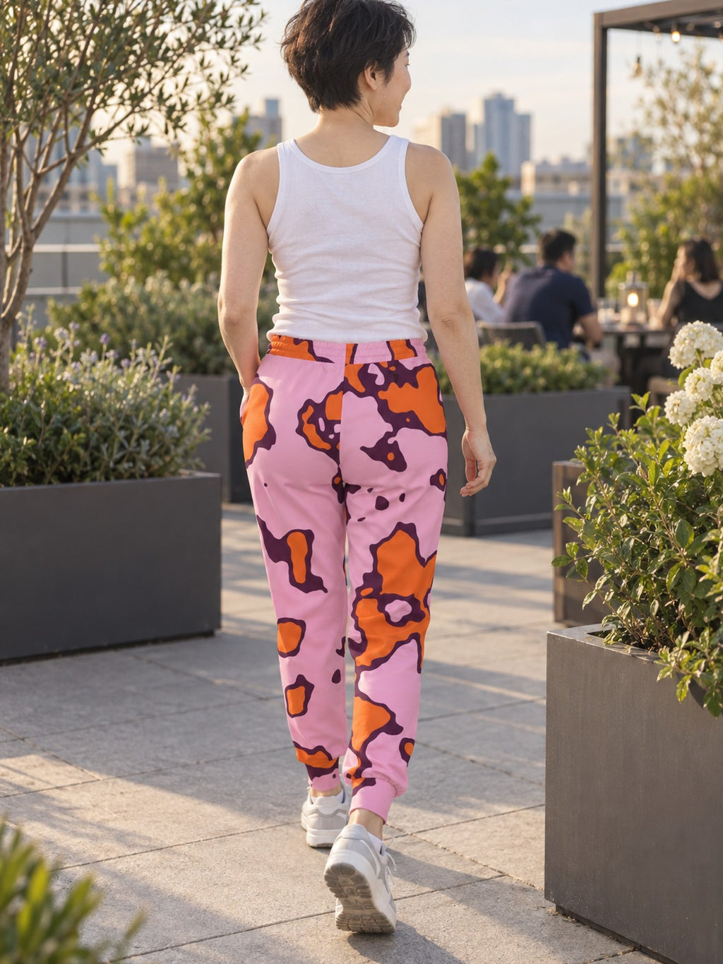 Woman wearing Vantacore Tangerine Spots all-over print joggers, back view