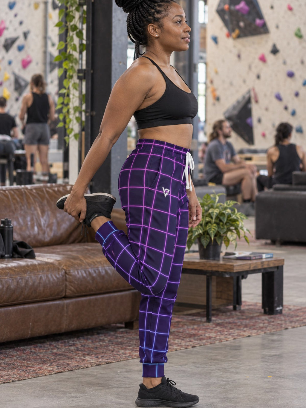 Woman wearing Vantacore Neon Grid all-over print joggers, side view