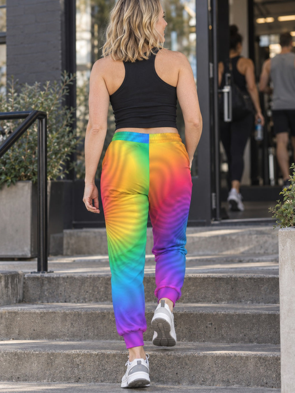 Woman wearing Vantacore Rainbow Tie-Dye all-over print joggers, back view