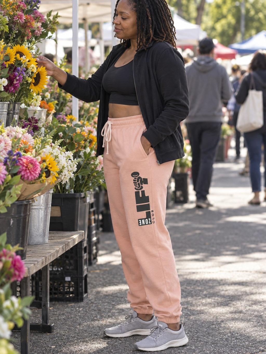 Woman wearing Vantacore LIFT Zone Club graphic sweatpants in Peachy, side view