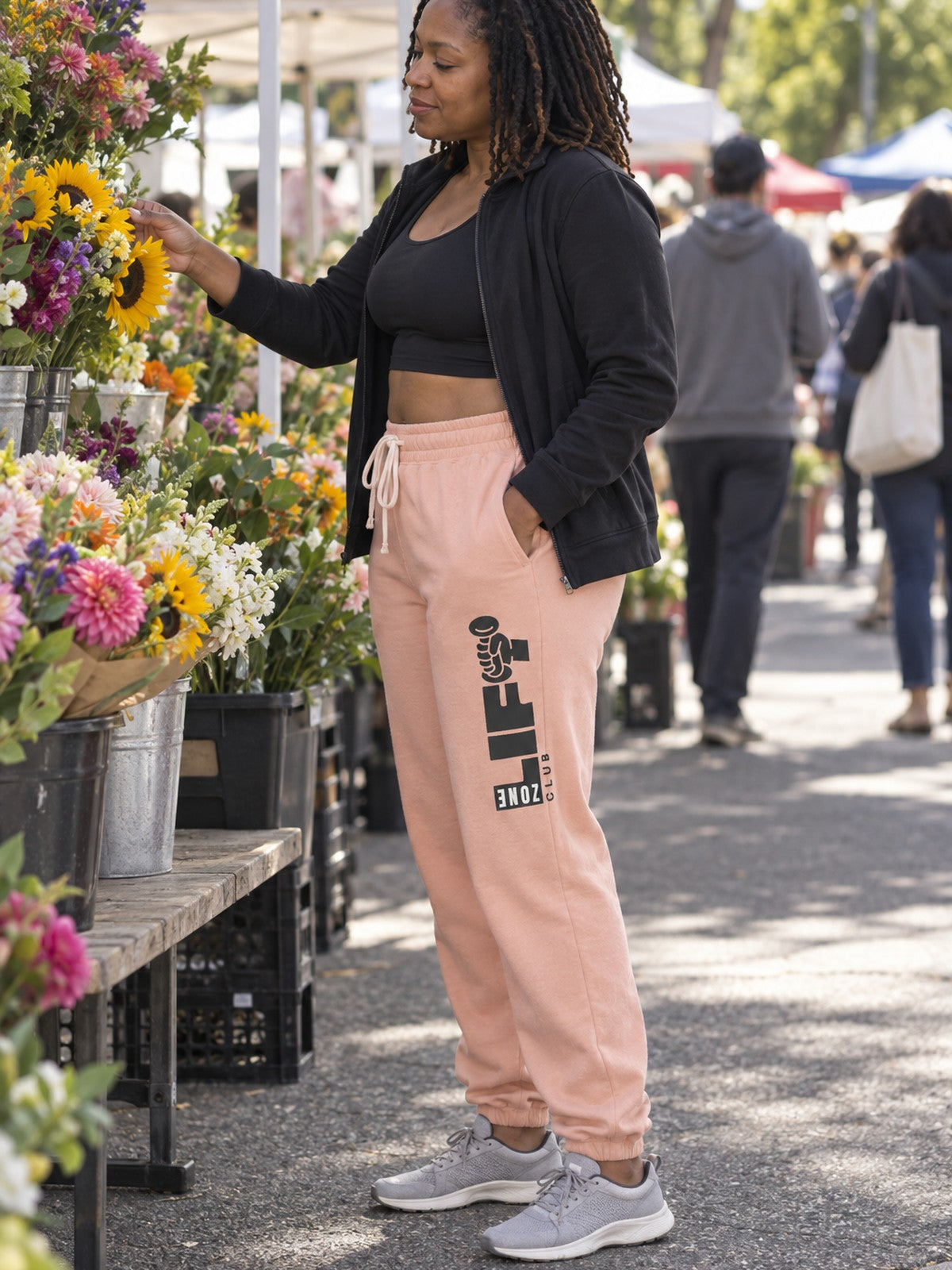 Woman wearing Vantacore LIFT Zone Club graphic sweatpants in Peachy, side view