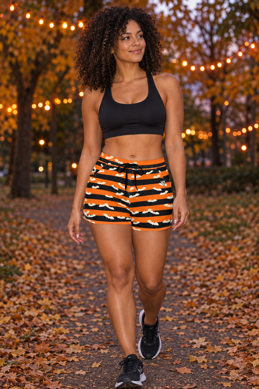Halloween Pumpkin Orange Bat Stripe women's lightweight athletic shorts worn on a model
