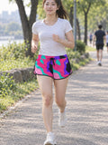 Woman wearing the Neon Camo relaxed all-over print shorts – front view