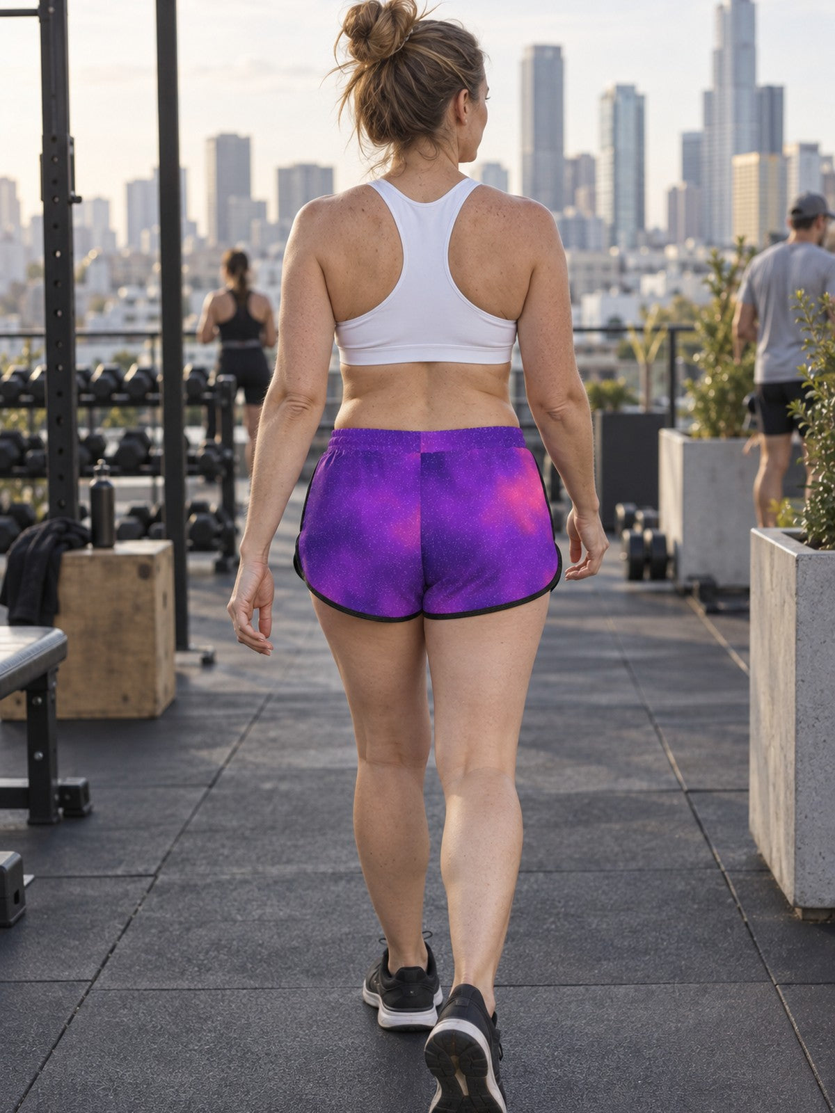 Woman wearing the Galaxy Glow relaxed all-over print shorts – back view